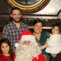Family of four posing with Santa Claus